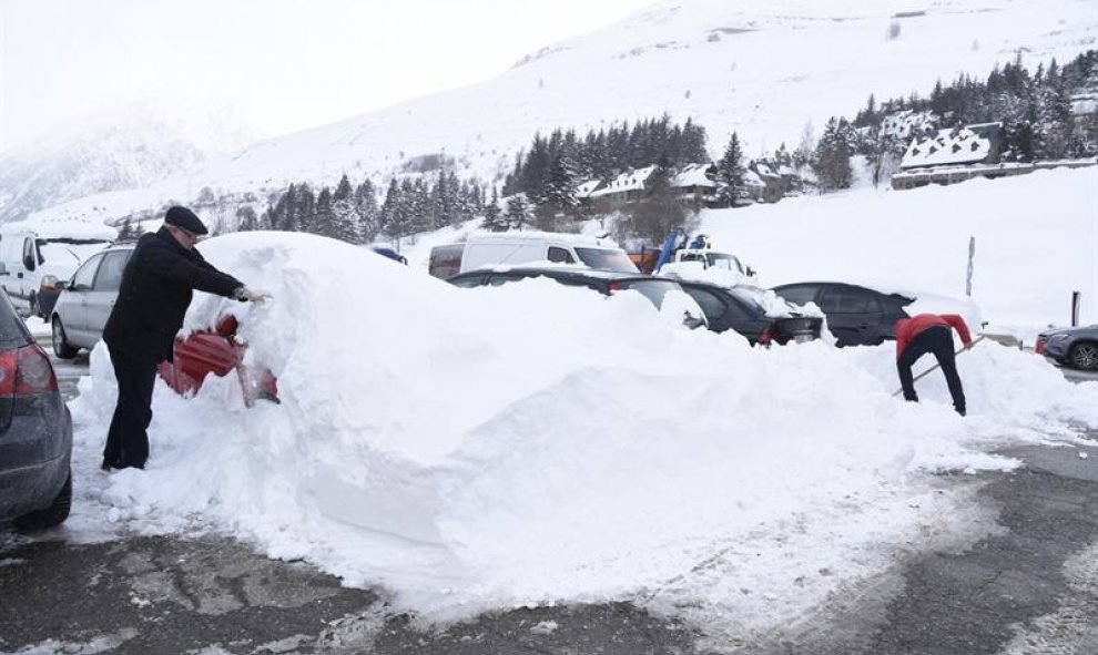 Vista de una pala quitanieves trabajando y varios vecinos colaborando en quitar la nieve en Baqueira Beret (Lleida) / EFE