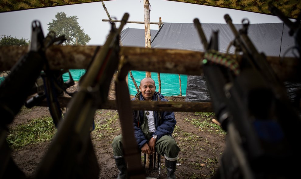 Un guerrillero de las FARC vigila las armas en la zona veredal de transición de La Fila, en Tolima. El proceso de desarme va más lento de lo acordado por los incumplimientos del Gobierno en varios puntos de los acuerdos con la guerrilla.- JAIRO VARGAS