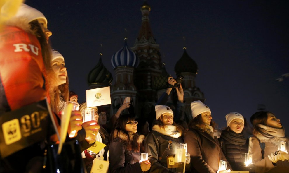 Ecologistas celebran la Hora del Planeta en Moscú. De fondo la Catedral de San Basilio con sus luces apagadas. REUTERS/ Maxim Shemetov