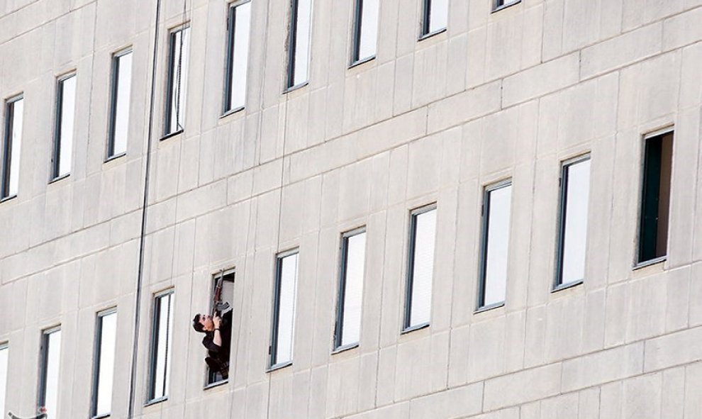 Miembro de las fuerzas de seguridad iranís apunta con su arma durante el ataque al Parlamento en el centro de Teherán. / REUTERS