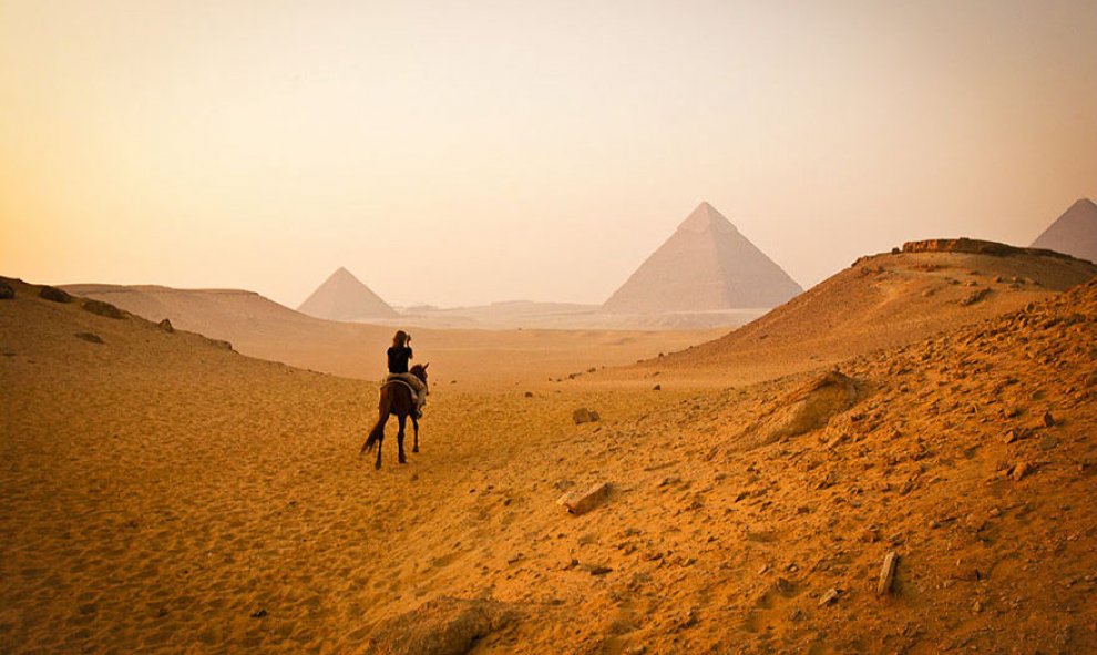 Una joven visita a caballo las pirámides de Giza, en Egipto /Architecture and Design