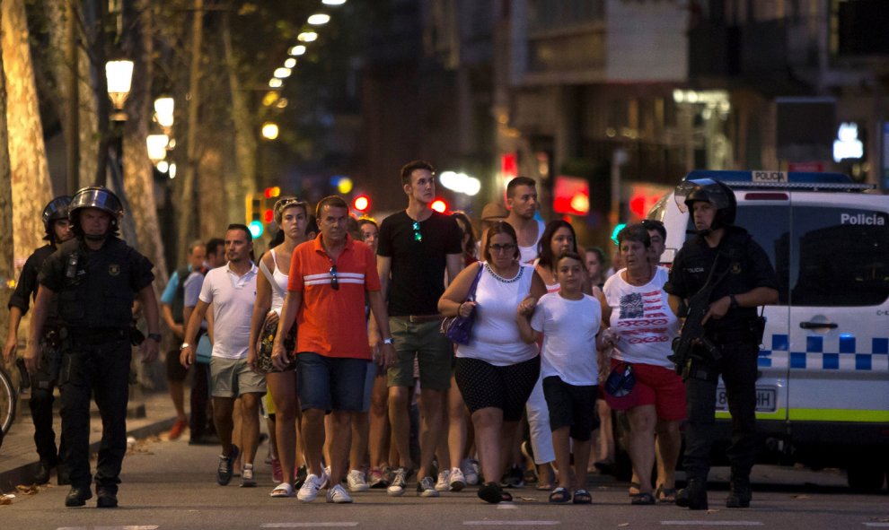 Varias personas esperan que los Mossos les permitan volver a sus casaS tras el atentado en Barcelona.- REUTERS