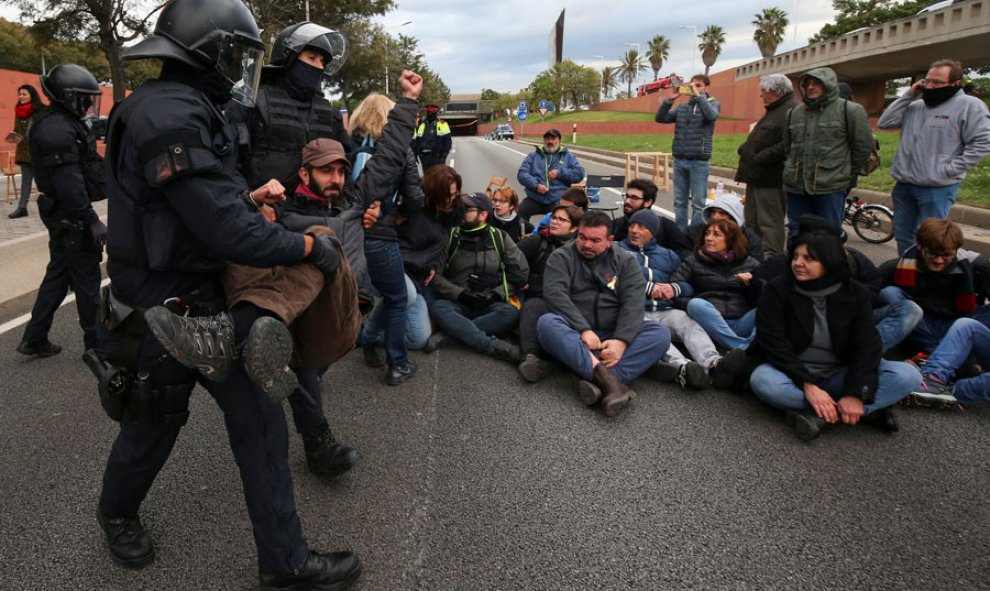 Los Mossos se llevan a una persona en Barcelona durante la huelga en Catalunya. REUTERS/Albert Gea