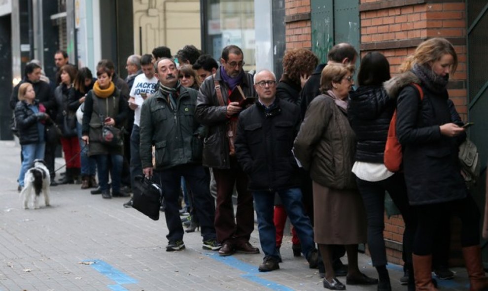 Varias personas hacen cola para votar en un colegio de Barcelona minutos antes de que abra sus puertas. /REUTERS
