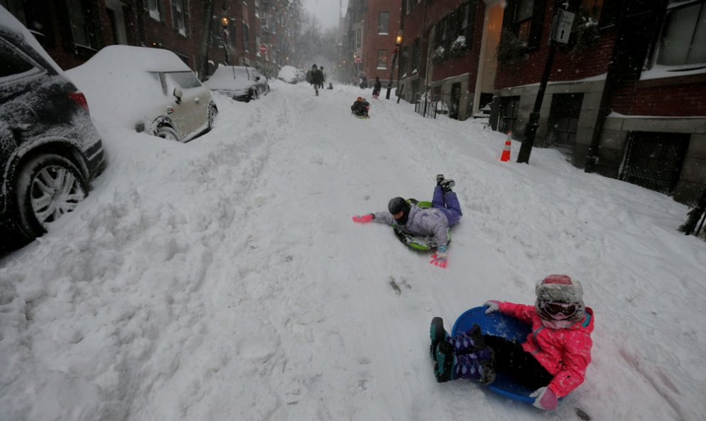 Un grupo de niños se desliza por una de las calles nevadas de Boston, en plena tormenta. REUTERS/Brian Snyder