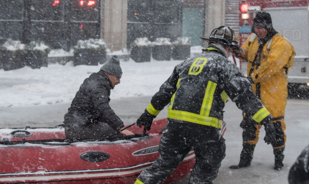 Bomberos de Boston rescatan a un hombre en medio de una tormenta de nieve. EFE/JOHN CETRINO