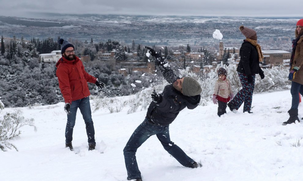Varias personas juegan con la nieve con la Alhambra de Granada de fondo, que ha recibido una intensa nevada y deja estampas invernales en la provincia y en la Capital Granadina.EFE/Miguel Ángel Molina