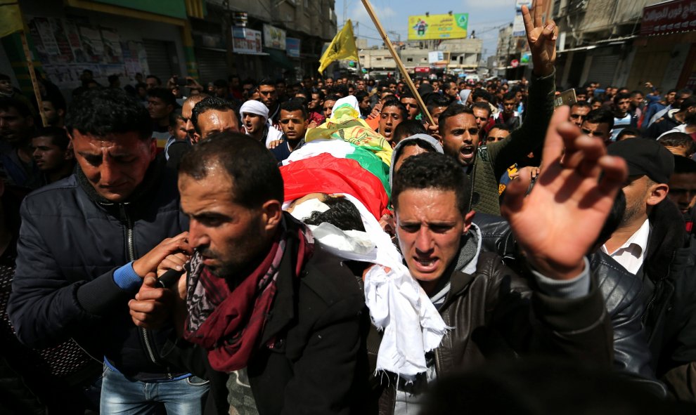 La multitud lleva el cadáver del agricultor palestino Omar Samour, asesinado la mañana de este viernes por las tropas israelíes cuando caminaba por sus tierras junto a la frontera de Israel con Gaza.- REUTERS / Ibraheem Abu Mustafa