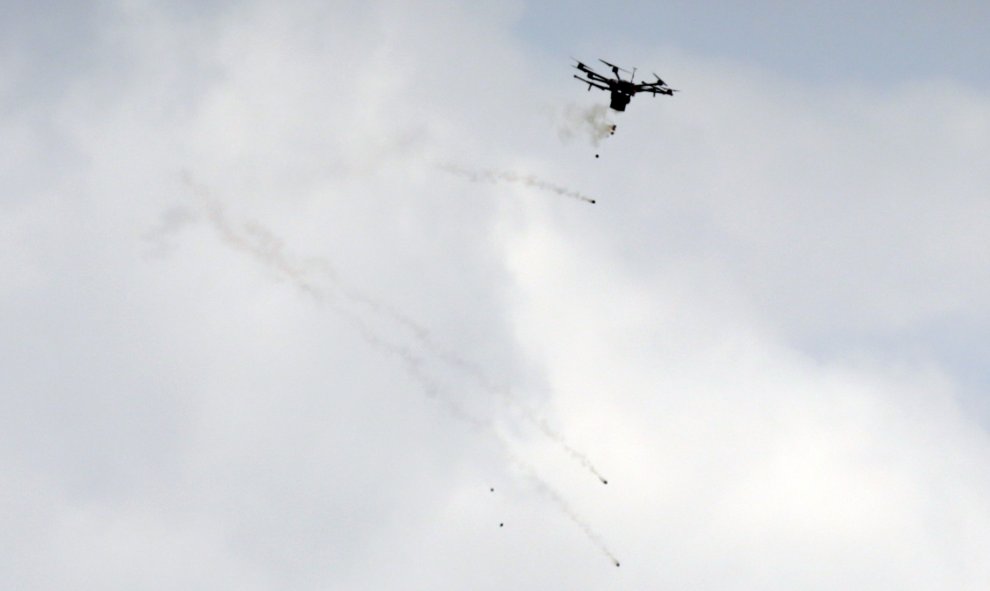 Un drone israelí que lanza granadas de gas lacrimógeno durante los enfrentamientos con manifestantes palestinos durante las protestas junto a la frontera con Israel al este de Jabalia en conmemoración del Día de la Tierra. - MAHMUD HAMS / AFP