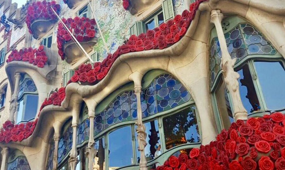 El edifico de la Casa Batlló de Gaudí en Barcelona, decorada con flores rojas por la Diada de Sant Jordi.