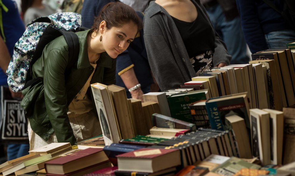 Una joven busca un libro en una de las paradas de las Ramblas de Barcelona.- EFE