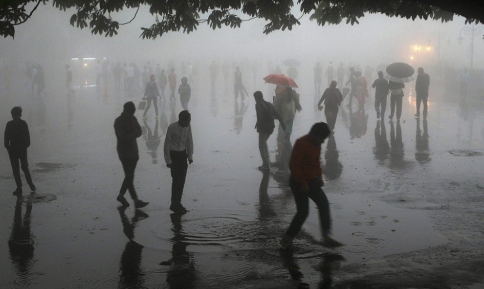 Personas caminando bajo las fuertes lluvias en la ciudad de Shimla, en el norte de la colina, en el estado de Himachal Pradesh. AFP