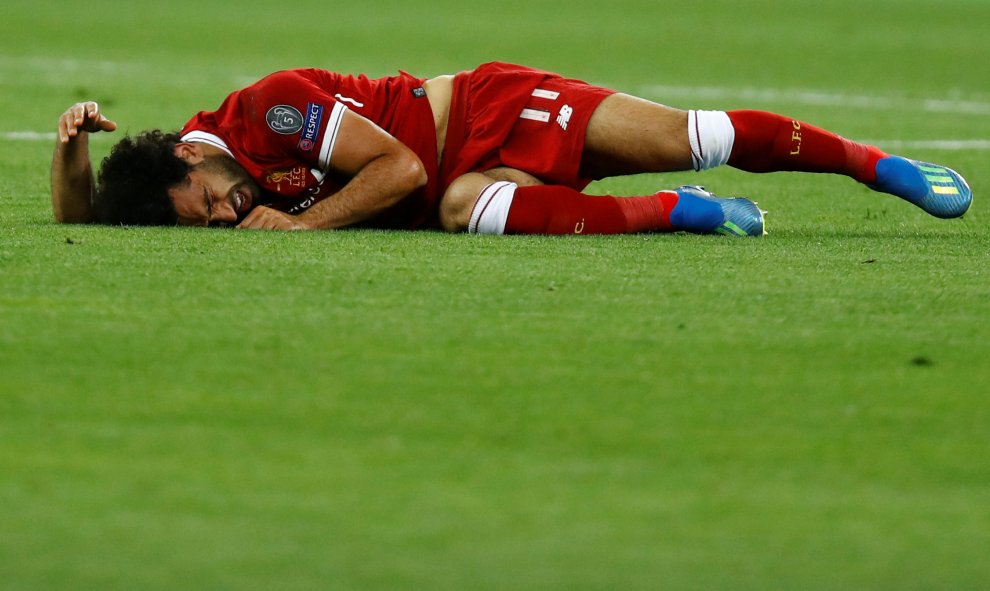Salah, tendido en el césped tras la jugada en la que el futbolista del Liverpool acabó lesionado del hombro.- REUTERS