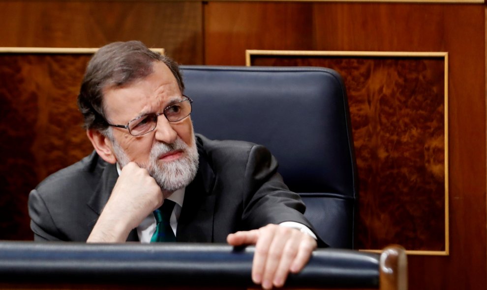 El presidente del Ejecutivo, Mariano Rajoy, atienda a la intervención del secretario de Organización del PSOE, José Luis Ábalos, la primera jornada de la moción de censura presentada por el PSOE contra el Gobierno. EFE/Javier Lizón