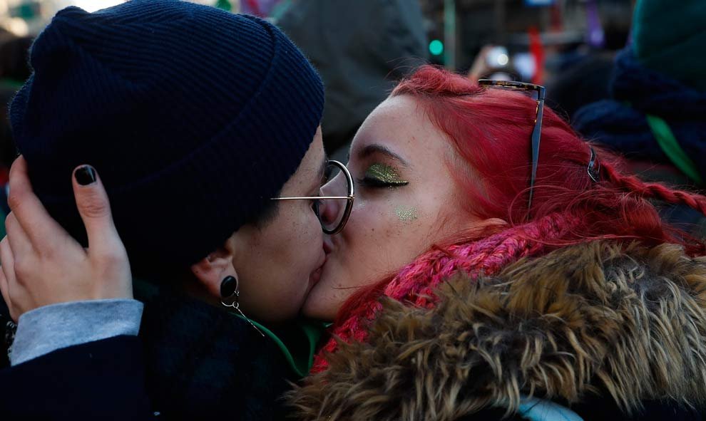 Dos mujeres se besan tras la aprobación de la ley del aborto. (DAVID FERNÁNDEZ | EFE)