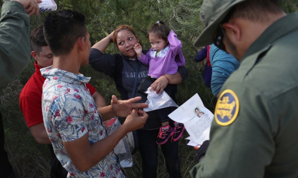 Los agentes de la Patrulla Fronteriza solicitan a un grupo de solicitantes de asilo centroamericanos que se quiten las cintas para el pelo y los anillos de bodas/AFP