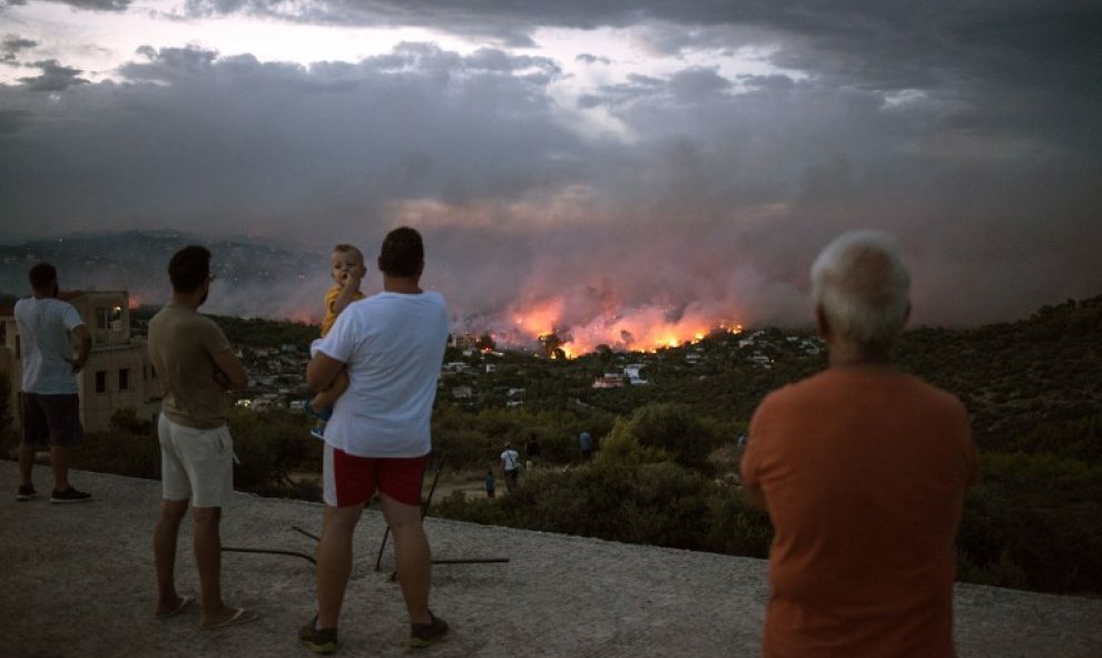 Vecinos observan el incendio de Rafina, cerca de Atenas - AFP