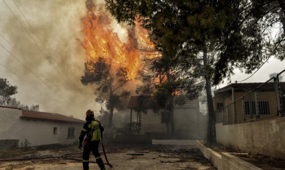 Un bombero trata de apagar las llamas del incendio de Kineta, cerca de Atenas - AFP