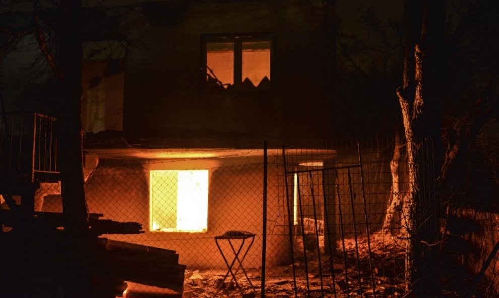 Una casa arde durante el incendio de Mati - AFP