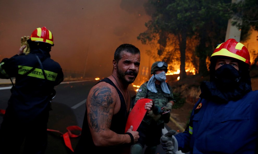Los bomberos y ciudadanos en la ciudad de Rafina, cerca de Atenas. REUTERS/Costas Baltas
