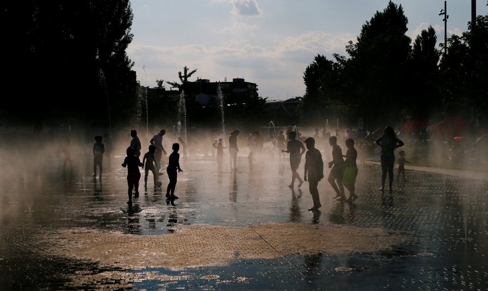 Niños juegan con el agua que brota de una fuente pública de la zona de Madrid Río. REUTERS/Javier Barbancho
