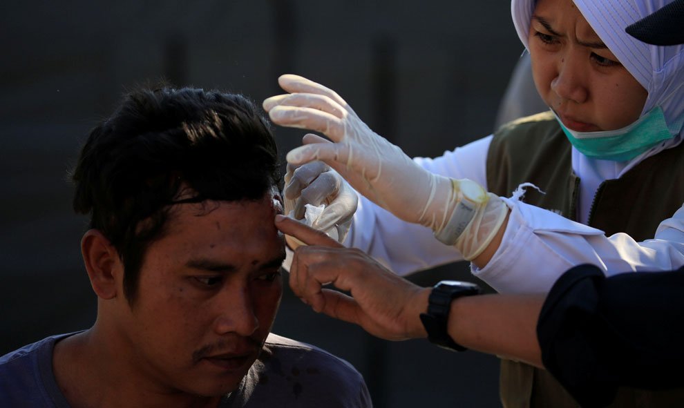 Una paramédico cura a un hombre herido fuera del hospital de Tanjung, después del terremoto en Lombok. / Reuters