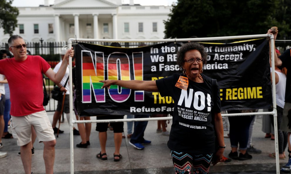 Una afroamericana grita durante las movilizaciones antifascistas delante de una pancarta del colectivo LGTBI | REUTERS