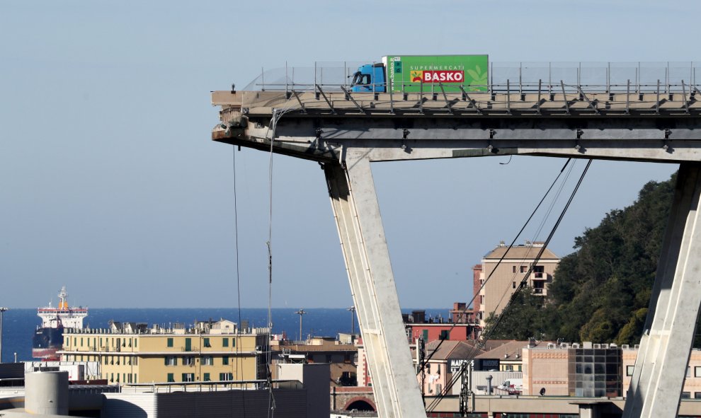 Un camión permanece al borde de la sección que continúa en pie del puente que el martes se desplomó en Génova (Italia). REUTERS/Stefano Rellandini
