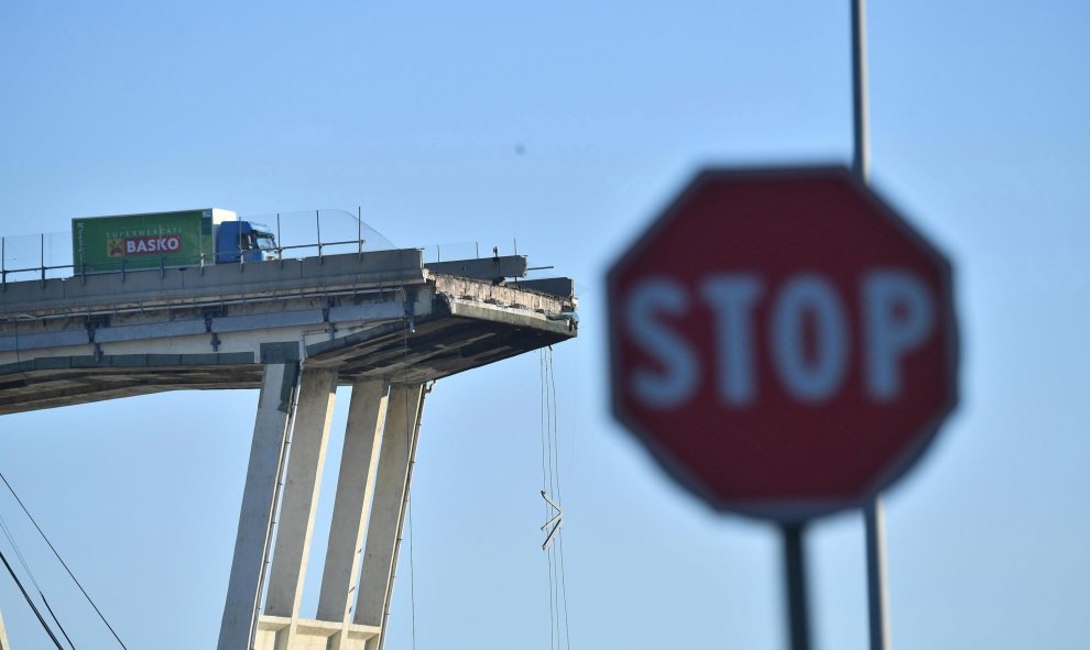 Un camión permanece en una de las secciones de un puente que aún se mantienen en pie tras su derrumbe el martes en Génova (Italia). EFE/ Luca Zennaro