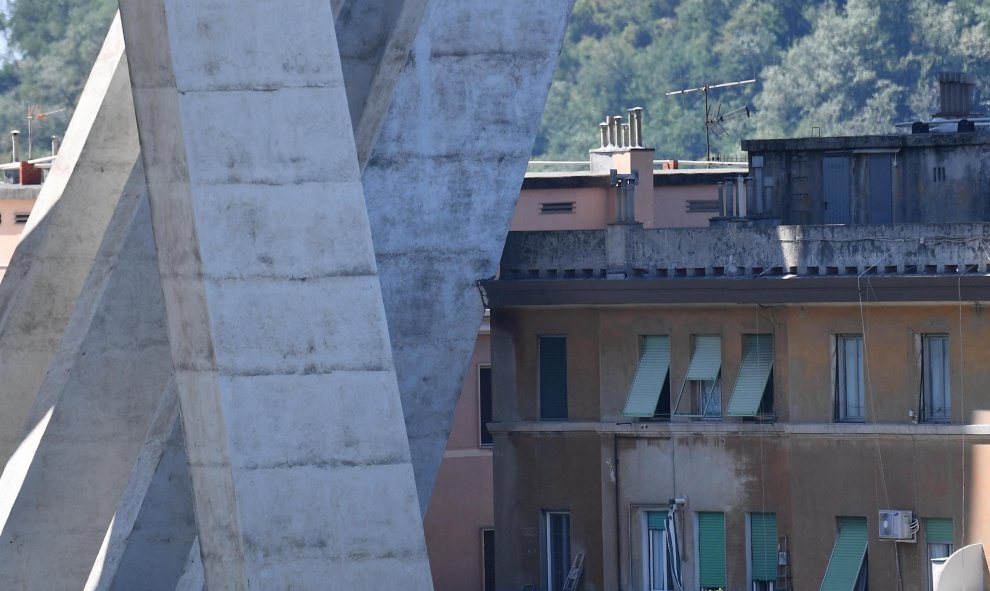 Detalle de una de las secciones de un puente que aún se mantienen en pie sobre unos edificios tras su derrumbe el martes en Génova (Italia). EFE/ Luca Zennaro