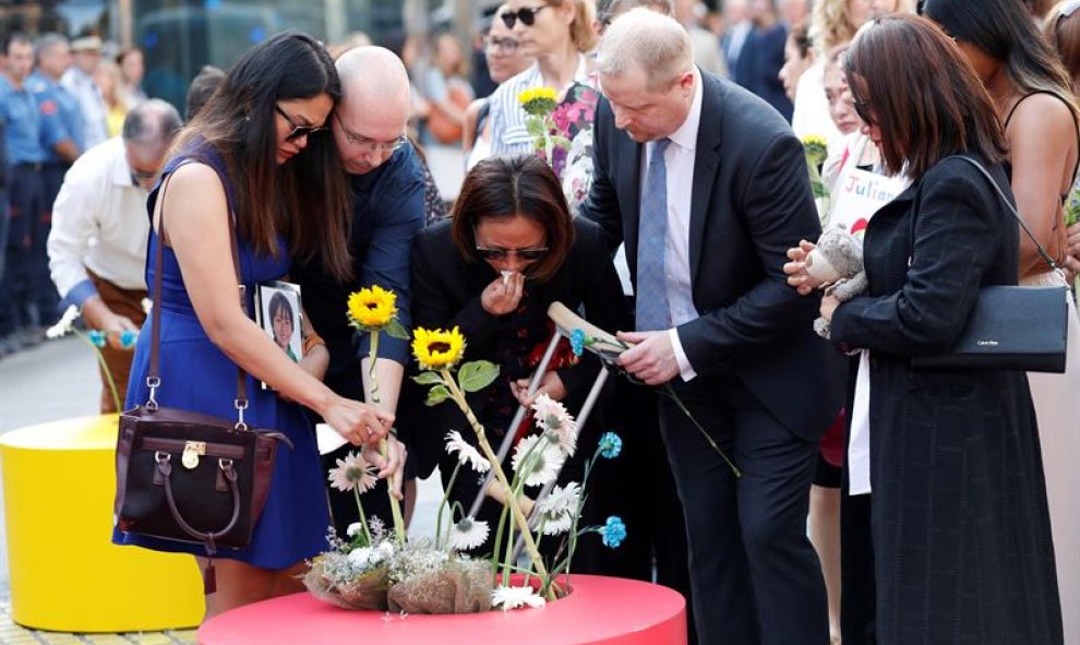Algunos familiares de las víctimas dejan flores a modo de ofrenda en los maceteros habilitados para ello | EFE / Alejandro García