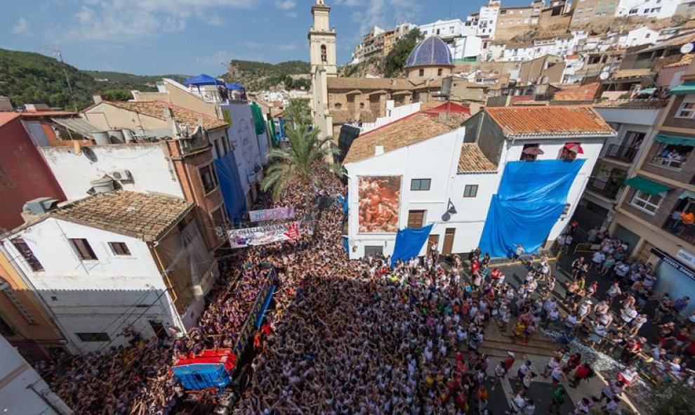 29/08/2018.. El centro de Buñol ha comenzado ya a teñirse de rojo con el lanzamiento desde varios camiones de los 145.000 kilos de tomate con los que 20.000 personas lucharán durante una hora hasta la extenuación festiva en la Tomatina de este pueblo val