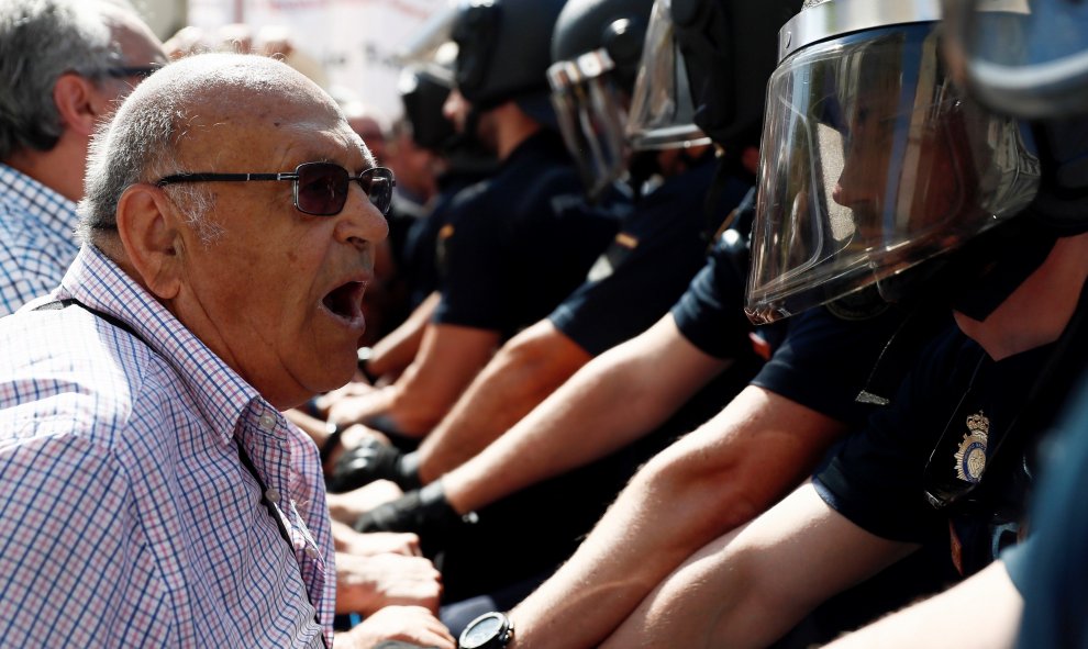 Un pensionista se encara con los policías en la concentración frente al Congreso de los Diputados pidiendo mejoras en sus prestaciones. EFE/Mariscal