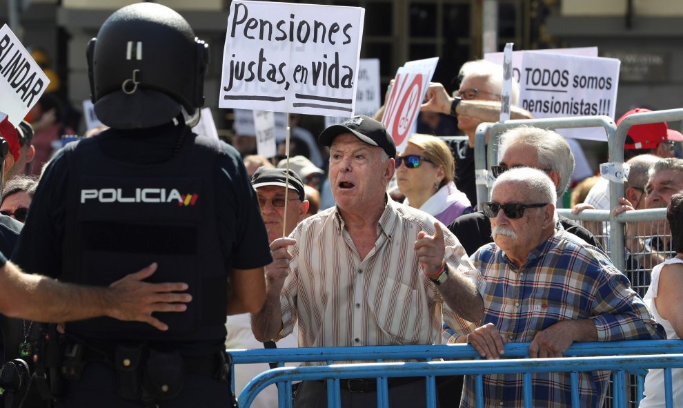 Grupos de pensionistas que se concentraron en el Congreso de los Diputados pidiendo mejoras en sus prestaciones intentan romper el cordón policial intentaba impedir su paso hasta la cámara donde hoy estaba prevista una reunión del Pacto de Toledo. EFE/Bal