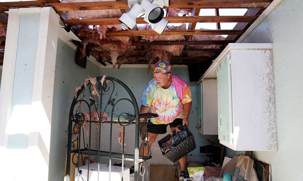 Mary Norris se para en el mostrador de la cocina y saca las pertenencias de la casa destruida de su amiga tras del huracán Michael en Mexico Beach, Florida, EE. UU., 11 de octubre de 2018. REUTERS / Carlo Allegri