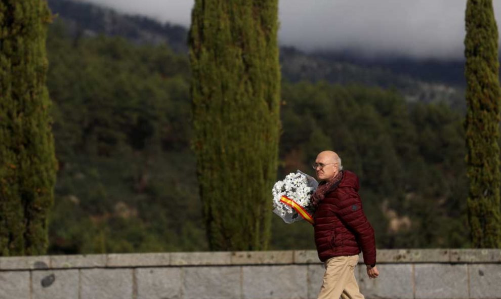 Un hombre con un ramos de flores se dirige a la basílica donde está enterrado Franco. (SUSANA VERA | REUTERS)