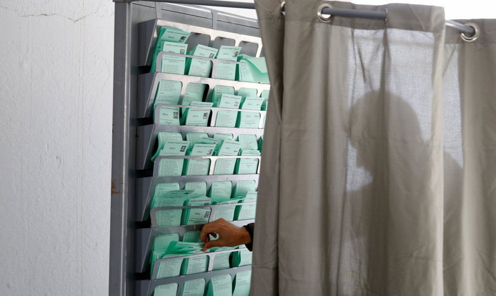 2/12/2018. Un hombre coge su papeleta antes de emitir su voto en las elecciones andaluzas en un colegio de Sevilla. REUTERS/Marcelo del Pozo