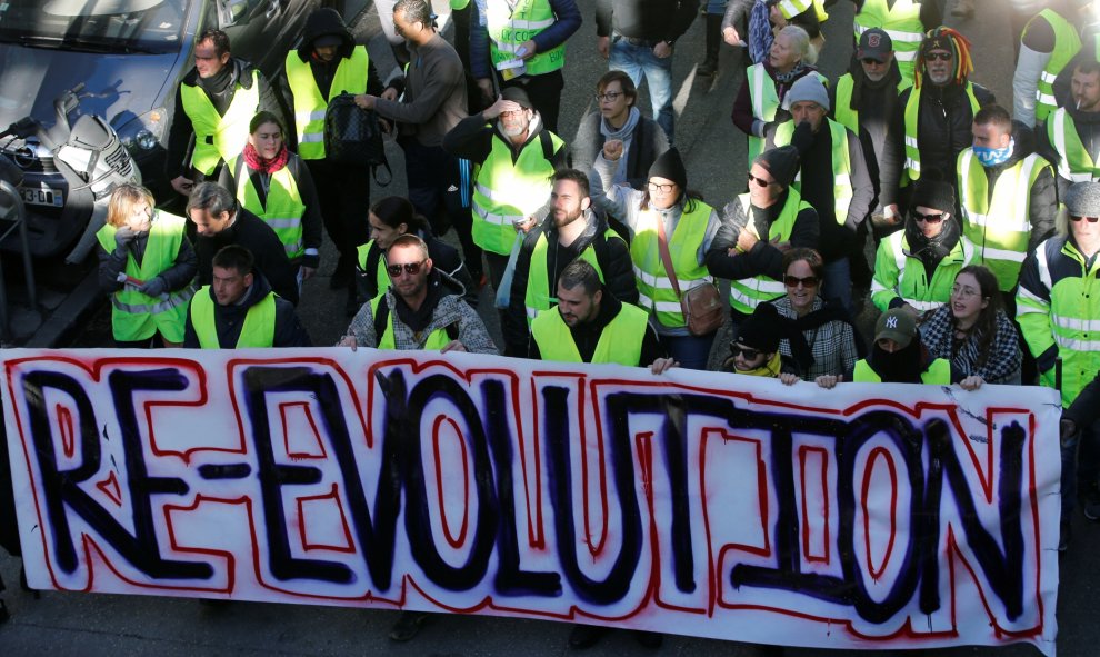 Los chalecos amarillos de Marsella portan una pancarta que llama a la "Re-evolución".- REUTERS/Jean-Paul Pelissier