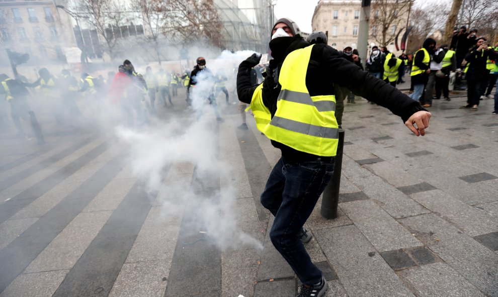 Un manifestante devuelve una granada de gas lacrimógeno a la Policía en París.- EFE/EPA/Ian Langsdon