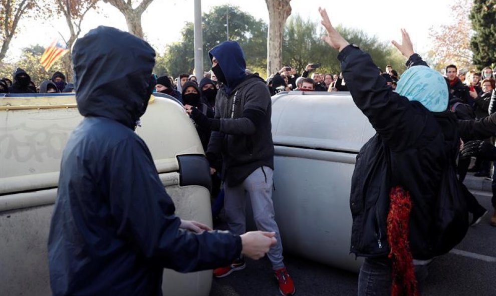 Manifestantes independentistas encapuchados vuelcan contenedores en las inmediaciones de la Llotja de Mar de Barcelona/EFE