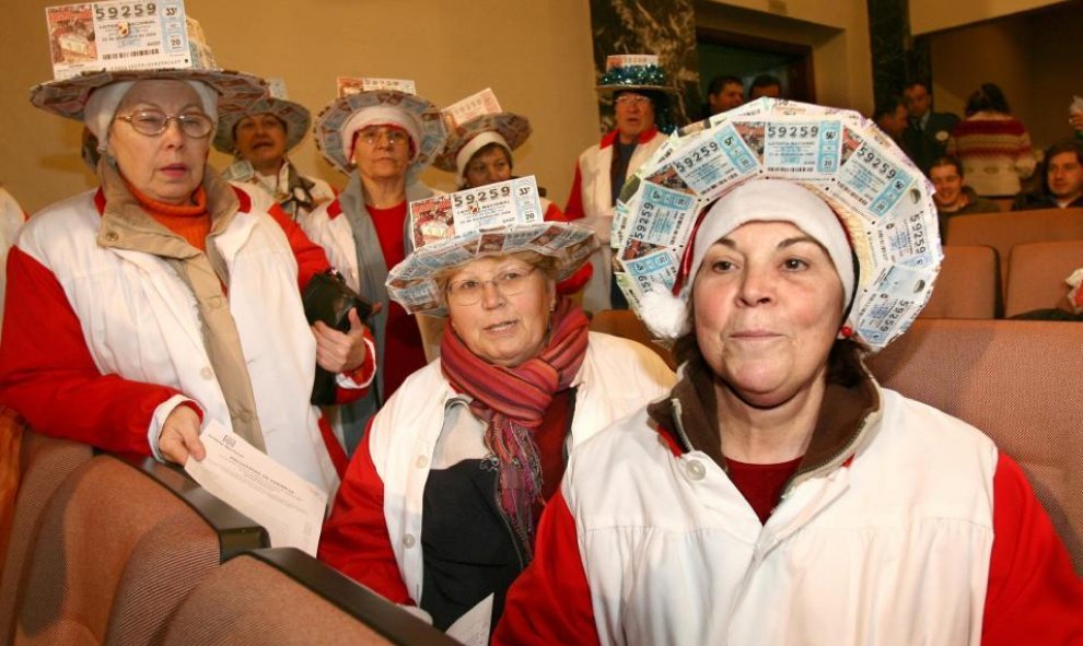 Un grupo de mujeres con sombreros echos con boletos.