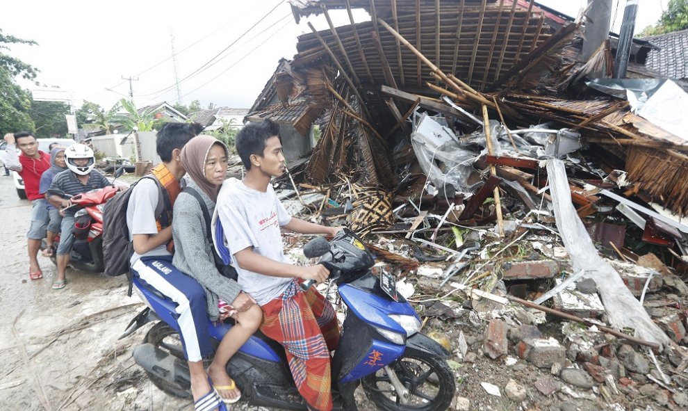 Varios residentes locales de Anyar transitan en moto cerca de una zona devastada por el tsunami de Indonesia.- EFE/EPA/ADI WEDA