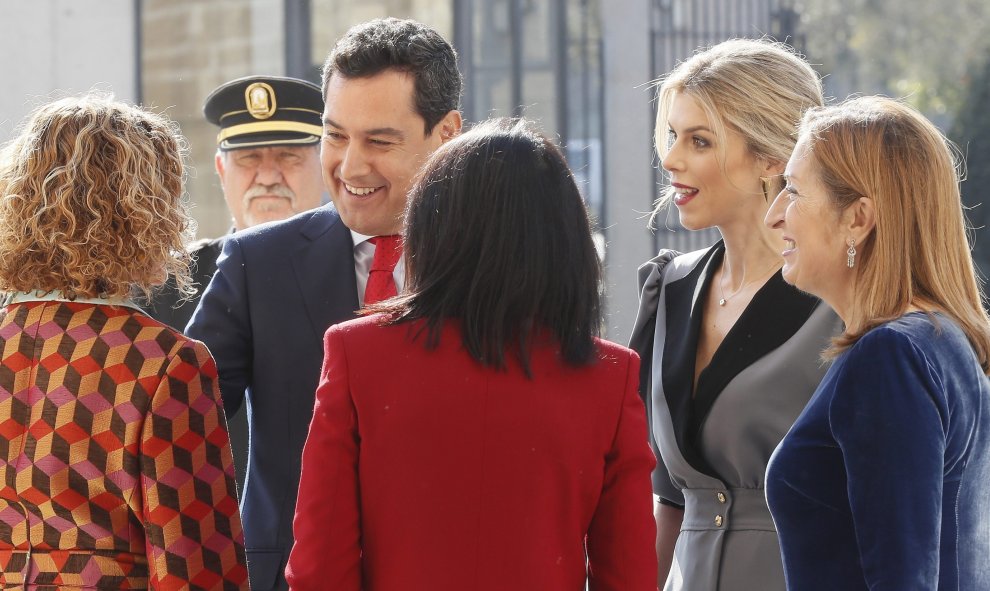 El presidente electo de la Junta de Andalucía, Juanma Moreno (c), junto a su esposa, a su llegada al Parlamento andaluz para tomar posesión de su nuevo cargo, donde ha sido recibido por la ministra de Política Territorial, Meritxel Batet (i), la president