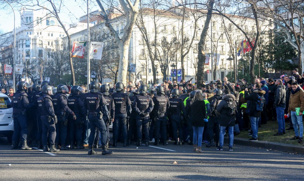 Agentes de la Policía Nacional intentan retener a la concentración de taxistas en el Paseo de la Castellana de Madrid, donde el colectivo acampó en su séptimo día de huelga. | Ricardo Rubio / Europa Press