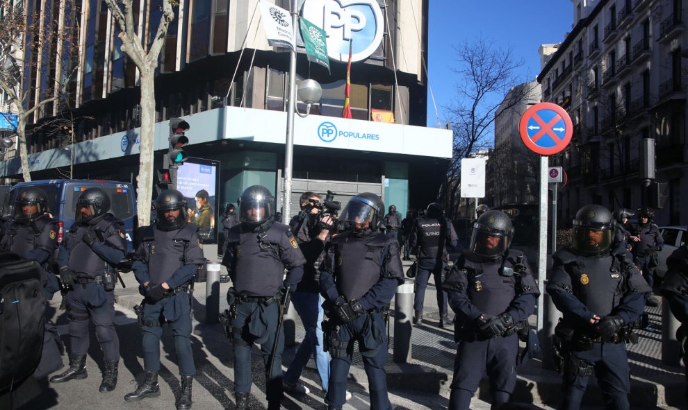 Agentes de la Policía Nacional protegen de los taxistas la sede del Partido Popular, situada en la calle Génova de Madrid. | Ricardo Rubio / Europa Press