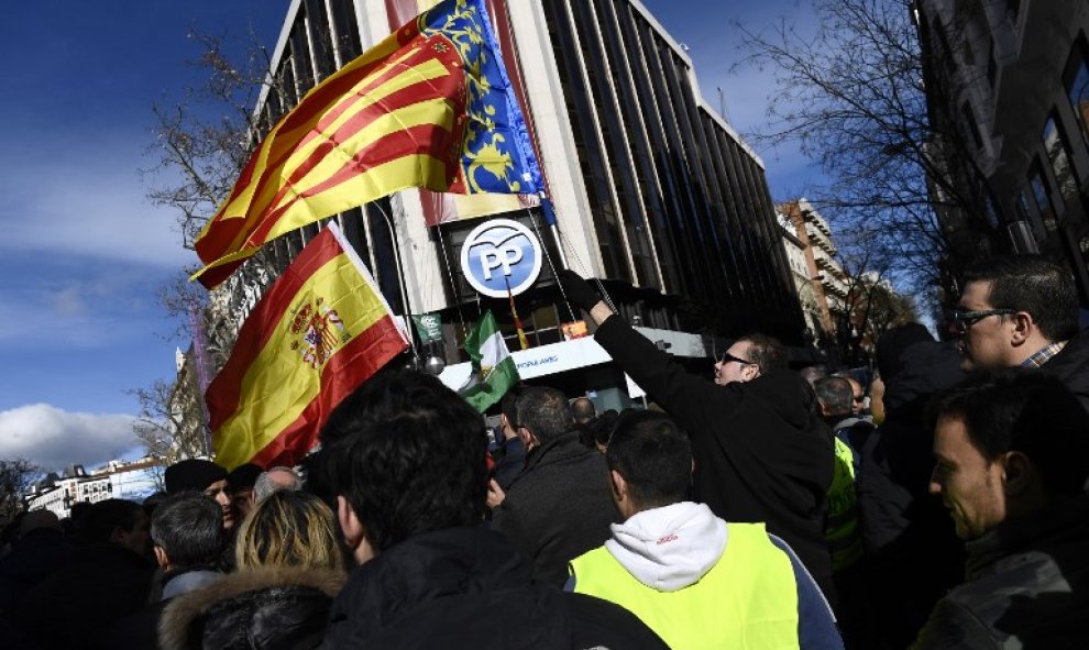 Un taxista con la bandera española y de la Comunidad Valenciana en la concentración frente a la sede del PP en la calle Génova. | PIERRE-PHILIPPE MARCOU / AFP