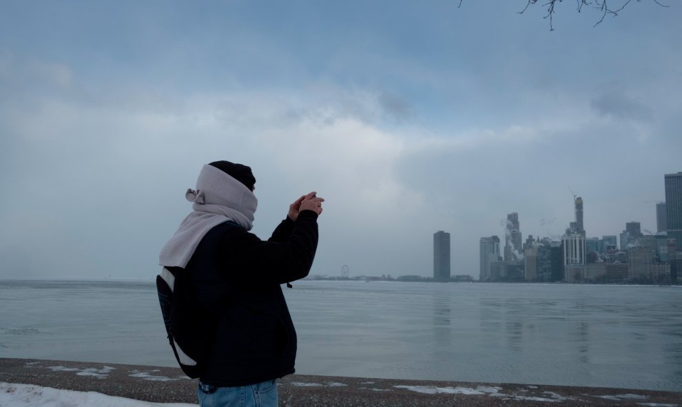 Una mujer toma una foto del horizonte de la ciudad desde la playa de North Avenue en el lago Michigan en Chicago. / REUTERS (Pinar Istek)