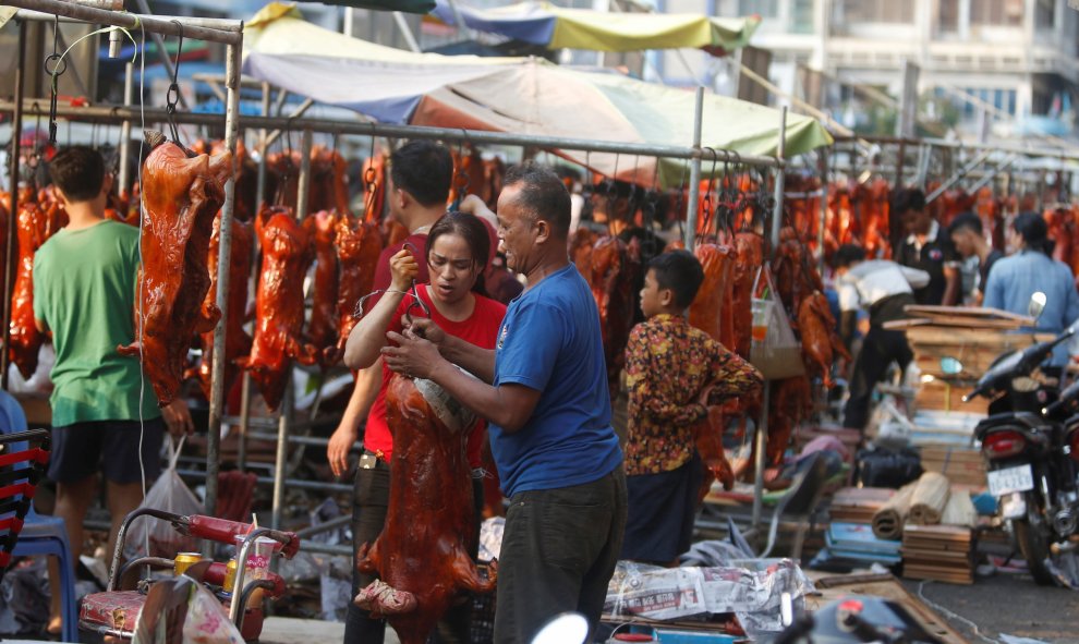 Los vendedores preparan cerdos asados ​​para la venta en una calle antes del Año Nuevo Lunar Chino, en Phnom Penh, Camboya | Reuters/Samrang Pring
