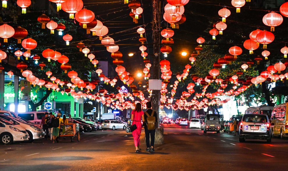 La gente camina bajo linternas decorativas antes del Año Nuevo chino en el distrito de Chinatown de Yangon, Birmania el 31 de enero de 2019 | AFP/Ye Aung Thu