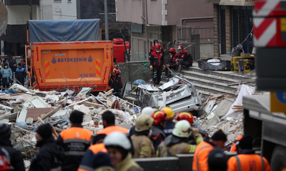 Varios miembros de los servicios de rescate se toman un descanso mientras continúan con las labores de búsqueda de supervivientes este jueves tras el derrumbe del edificio. / EFE (Erdem Sahin)